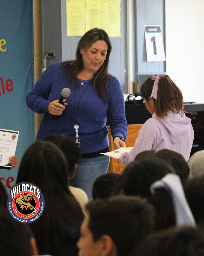 teacher smiles as kid receives award