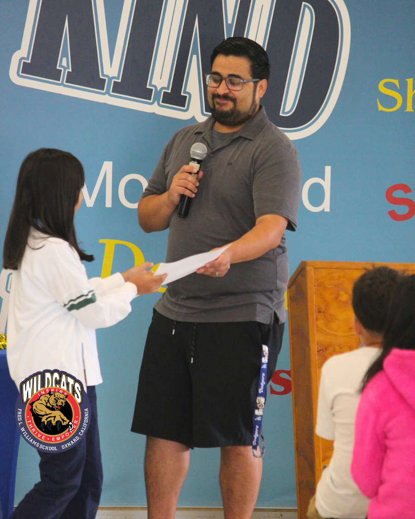 teacher smiles as kid receives award