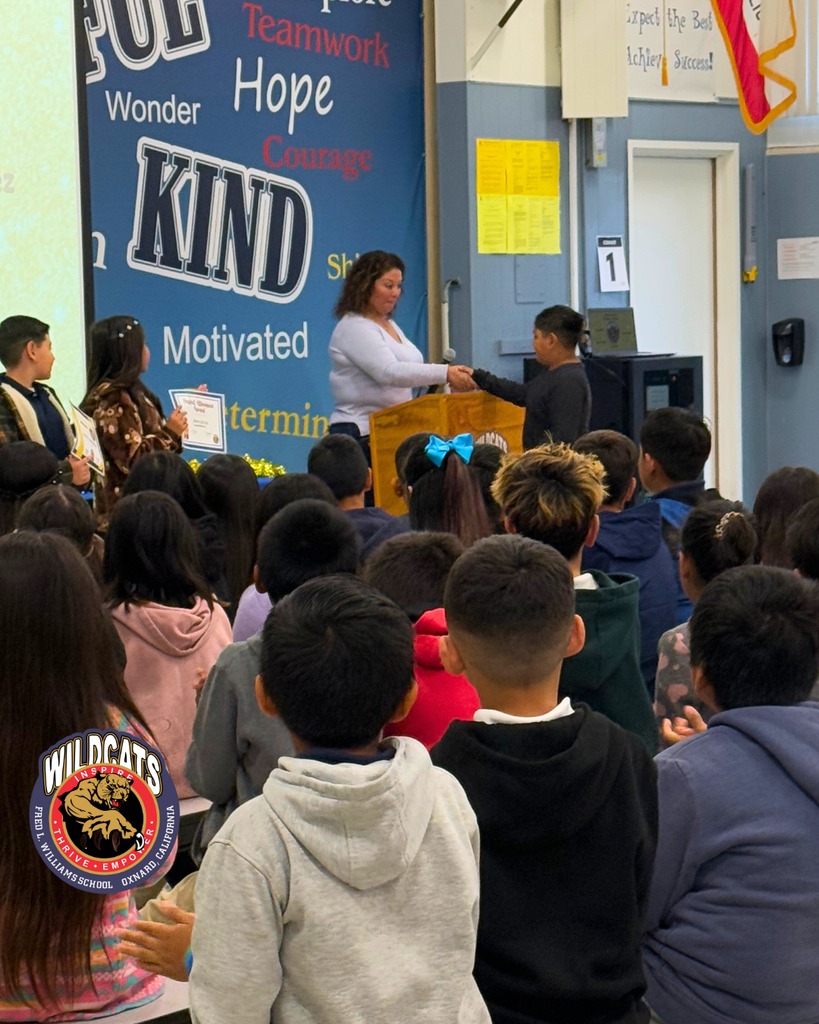 teacher smiles as kid receives award