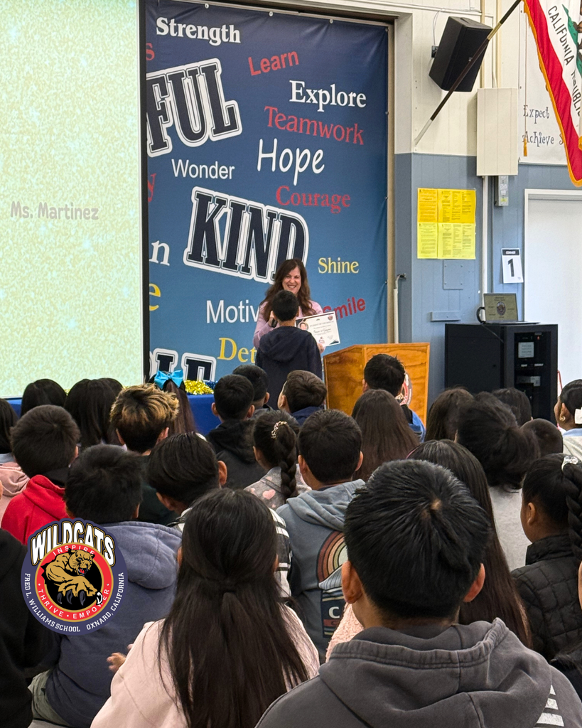 teacher smiles as kid receives award