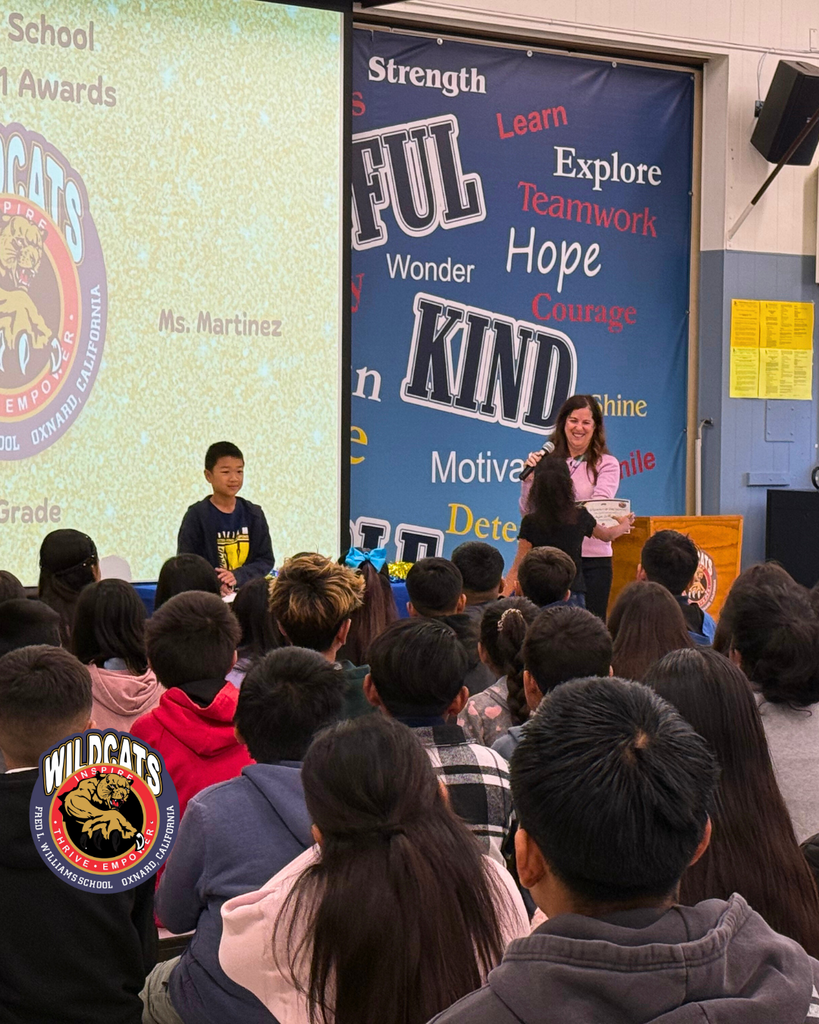 teacher smiles as kid receives award