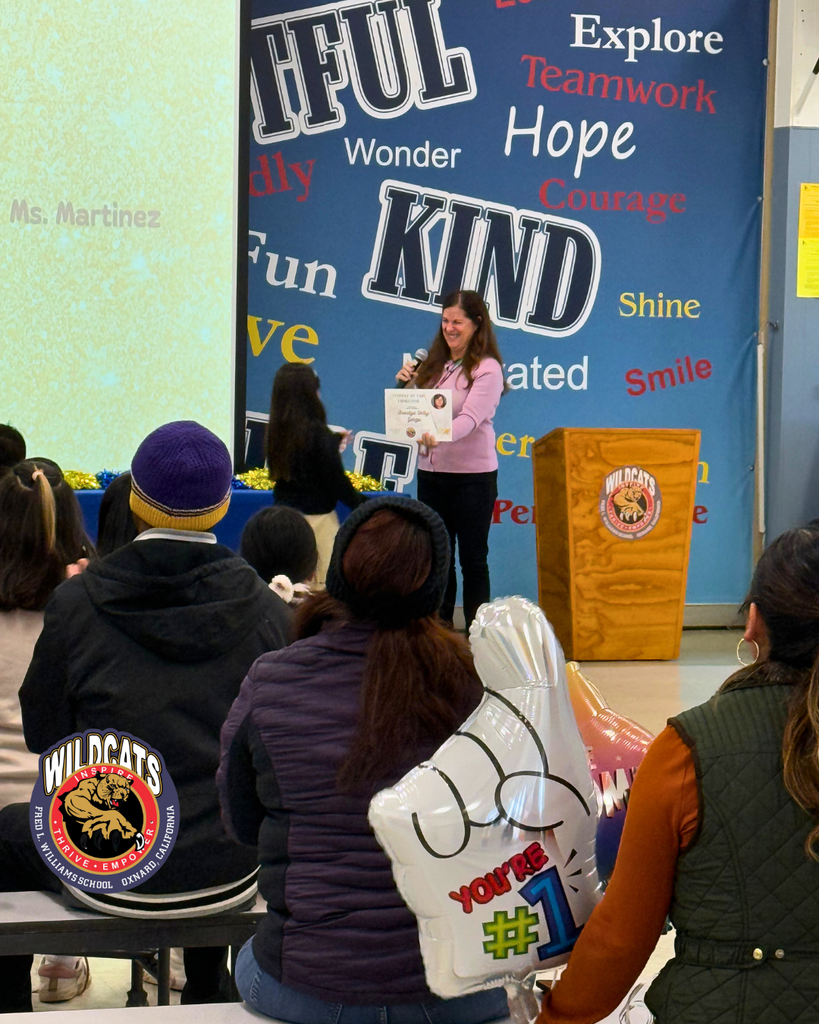 teacher smiles as kid receives award