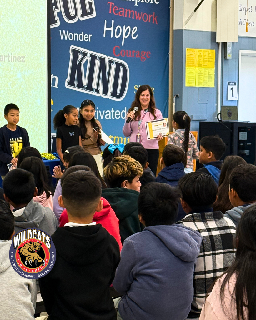 teacher smiles as kid receives award
