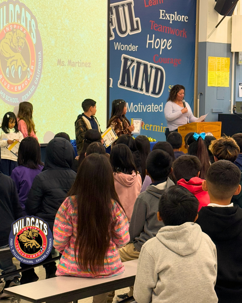 teacher smiles as kid receives award