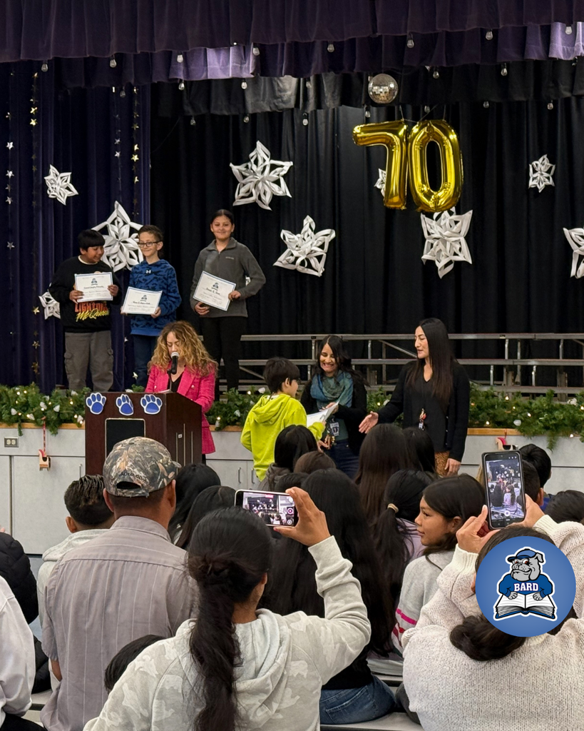 teacher smiles as kid receives award