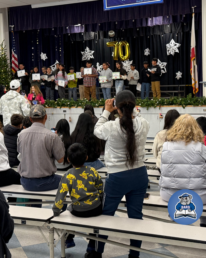 teacher smiles as kid receives award