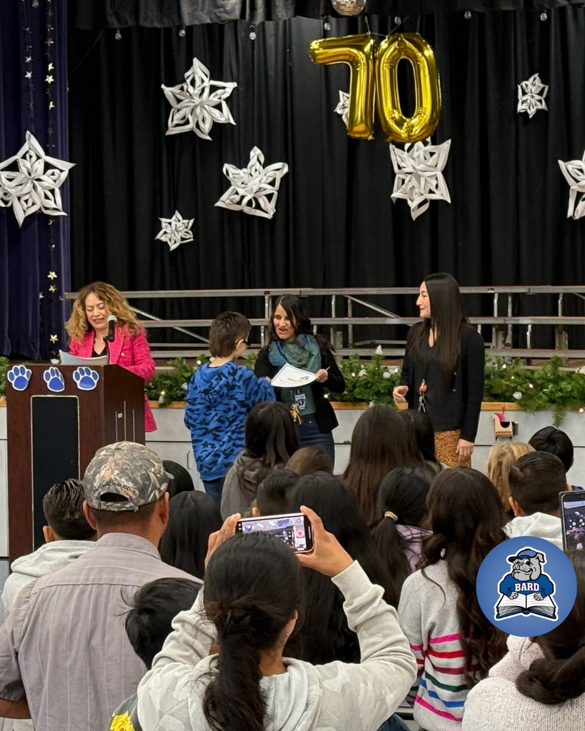 teacher smiles as kid receives award