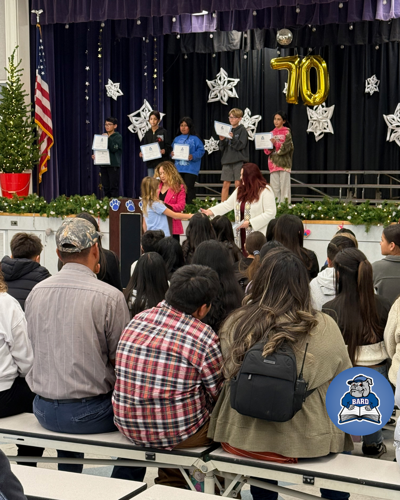 teacher smiles as kid receives award