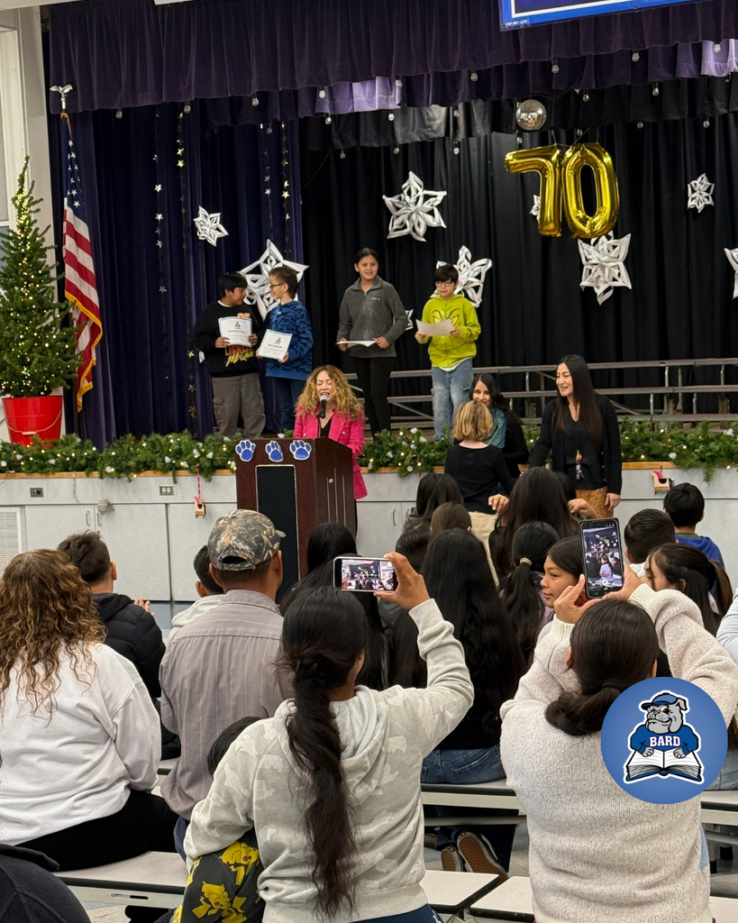 teacher smiles as kid receives award
