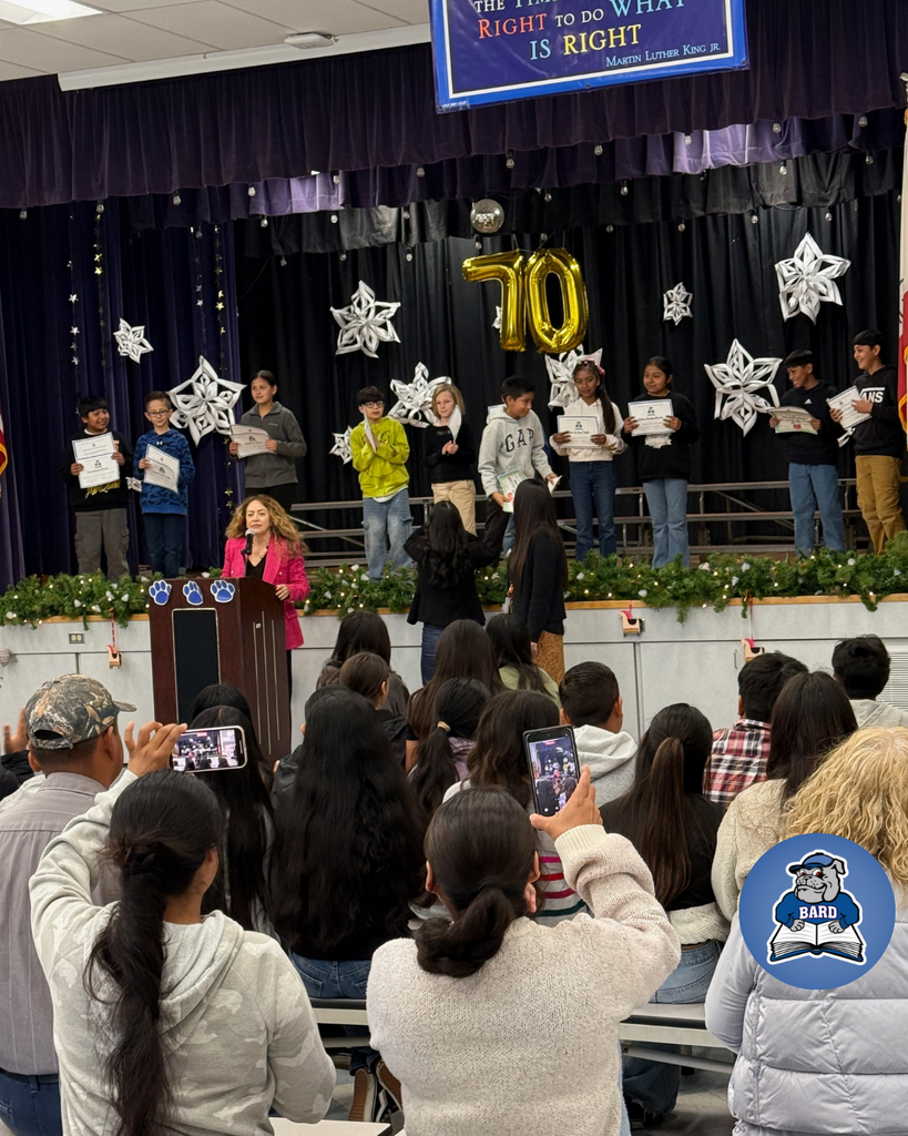teacher smiles as kid receives award