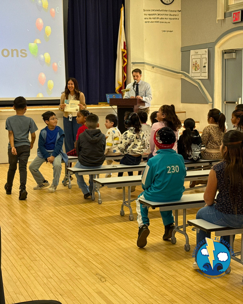 teacher smiles as kid receives award