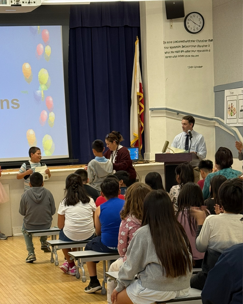 teacher smiles as kid receives award