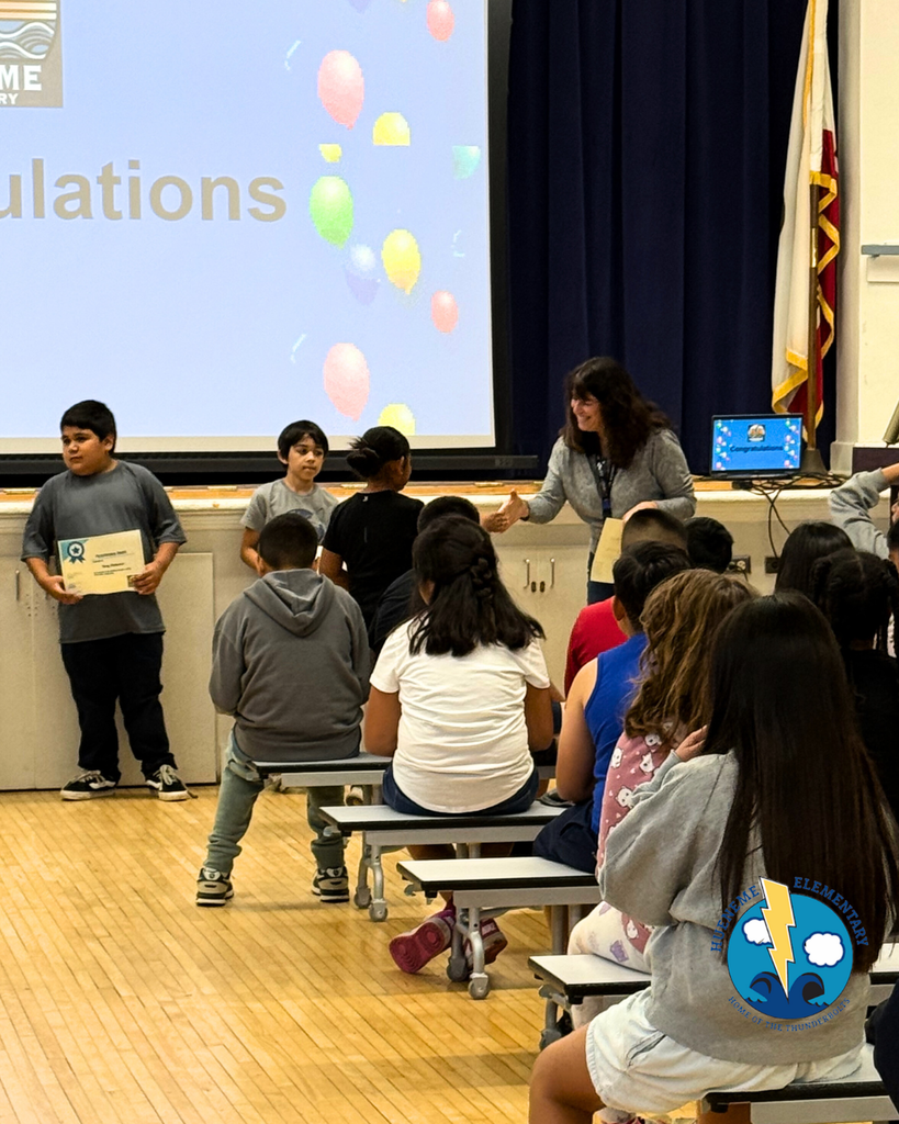 teacher smiles as kid receives award