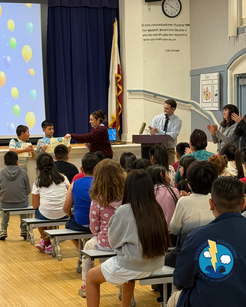 teacher smiles as kid receives award