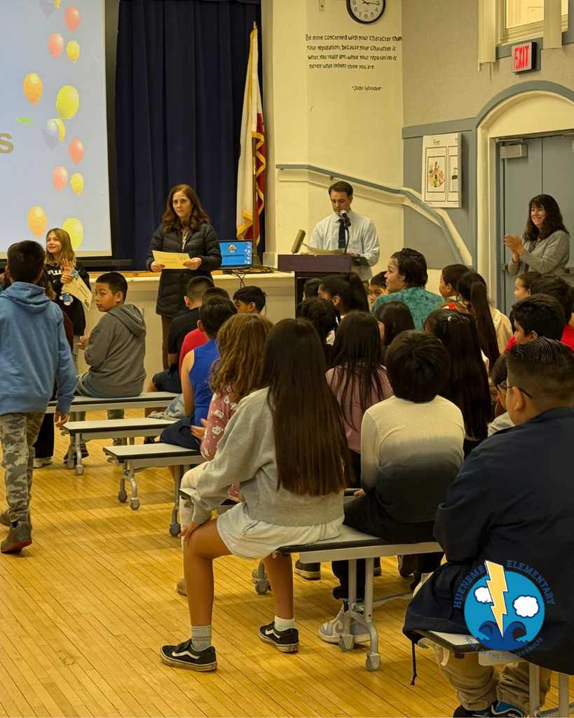 teacher smiles as kid receives award