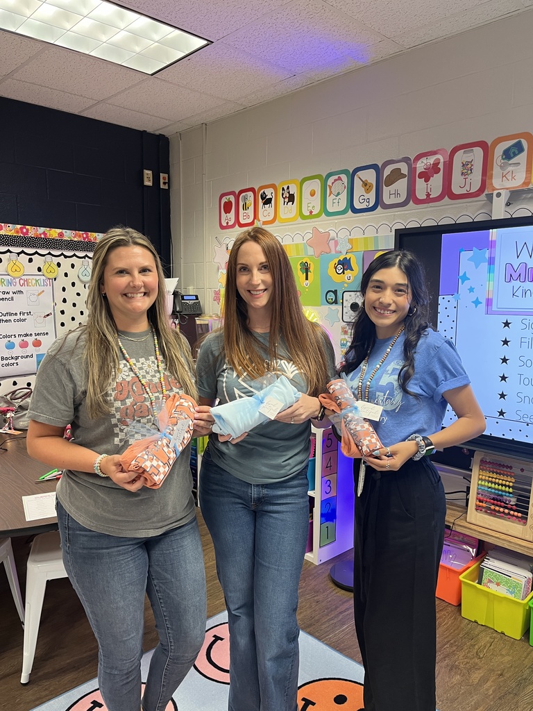 Kinder teachers holding spirit shirts.