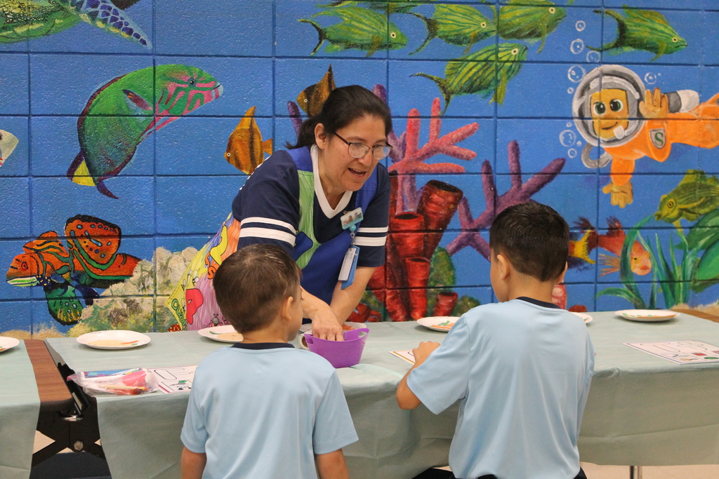 ECC Para Diana Cortez demonstrates a literacy game at HHM Literacy Night