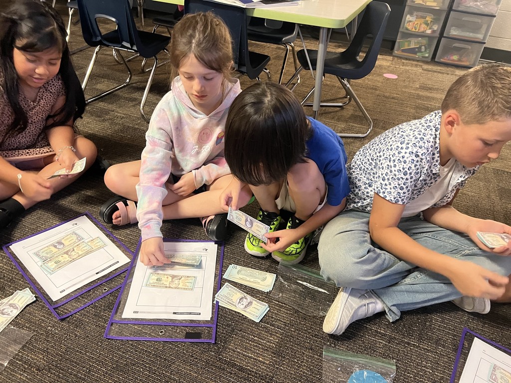 Second grade students collaborating to count money