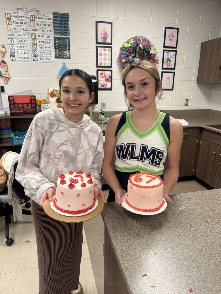 Students standing with a cake that they decorated