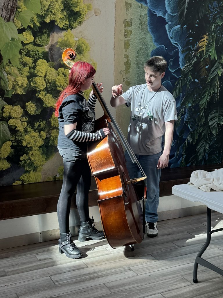 KPHS Orchestra Member shows KMS student the bass. 