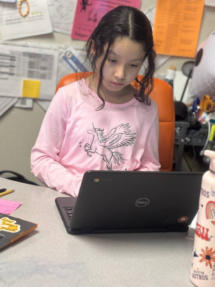 student working at teachers desk