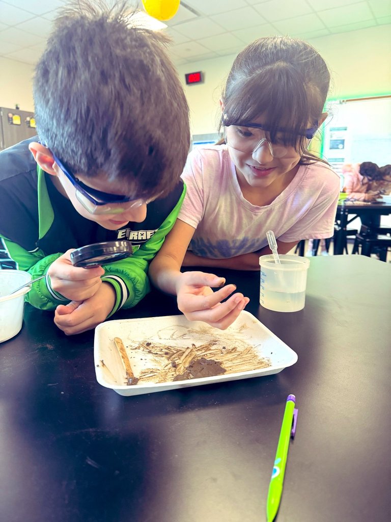 Students discovering the feeling of mixing water and clay.