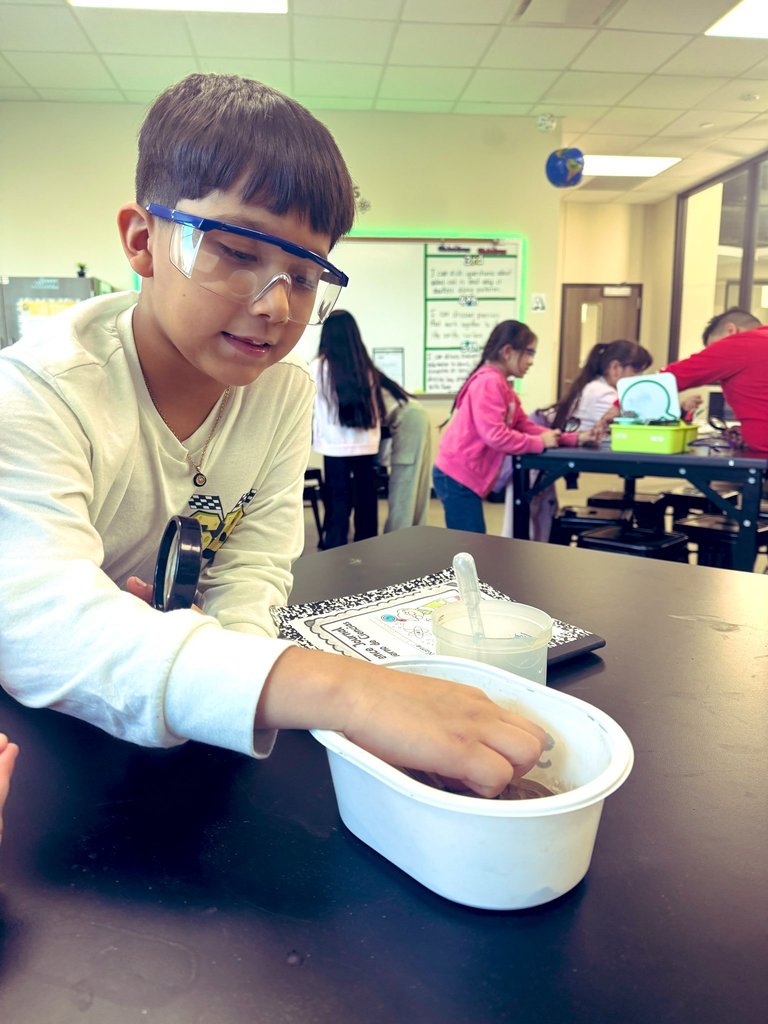 Student touching clay before adding water.