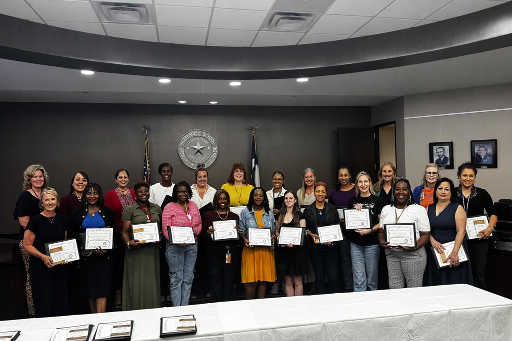 Large group of educators smiling and receiving awards at the Humble ISD BBTC building