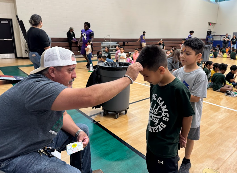 Coach giving students stickers to students.