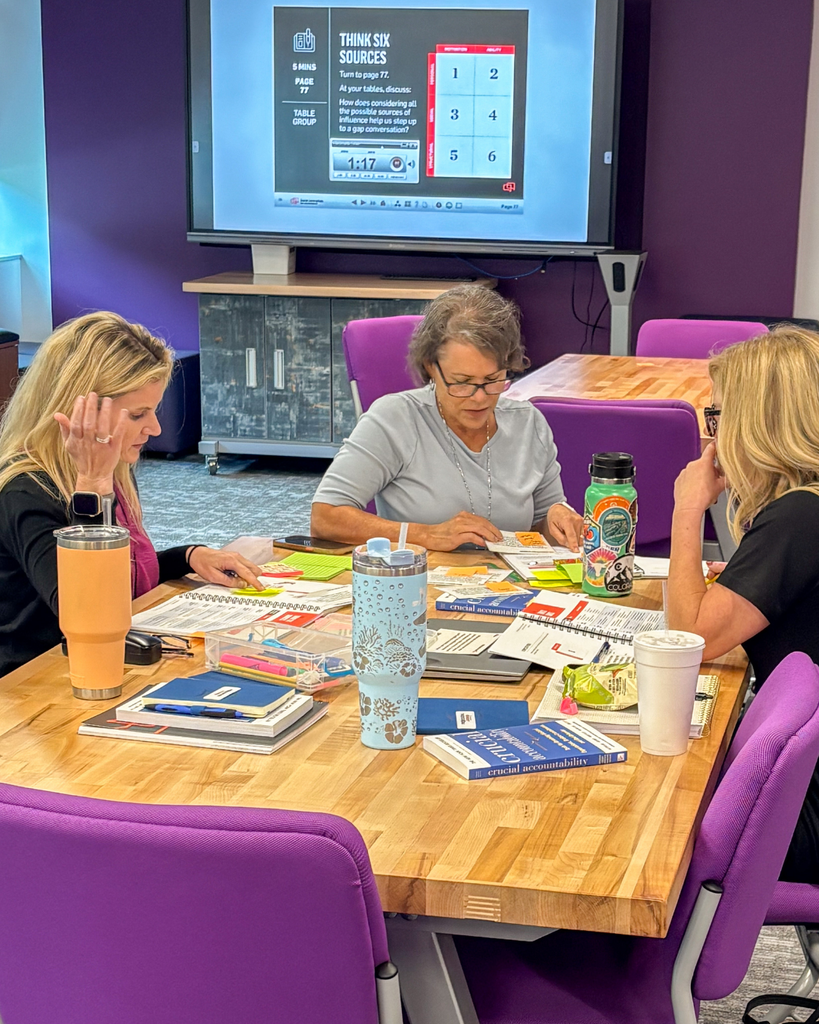 educators collaborating around a table with books and pamphlets