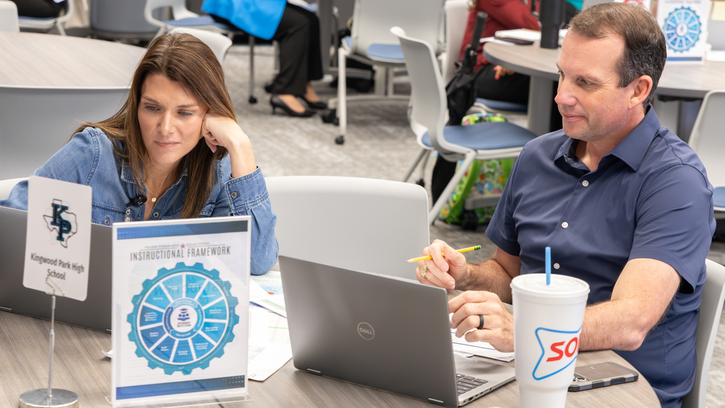 man and woman working on laptops and smiling