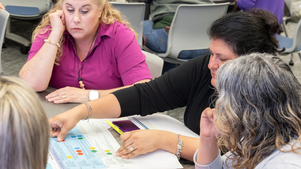 group of women putting stickers on a chart