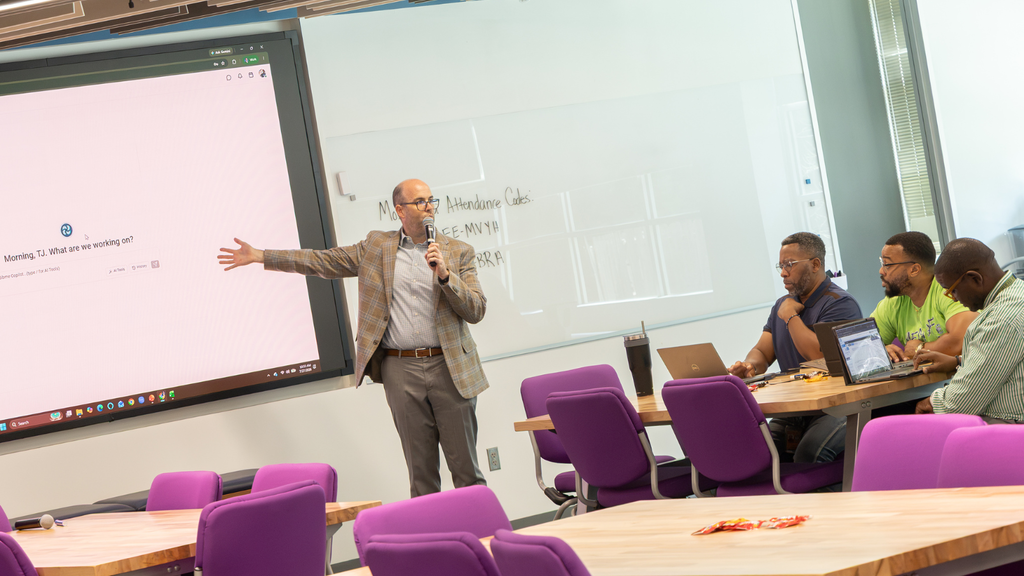 man pointing to screen during a presentation