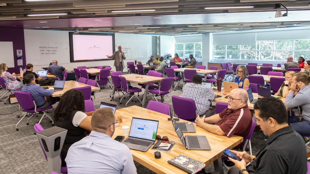 group shot of people learning and presenter at the board