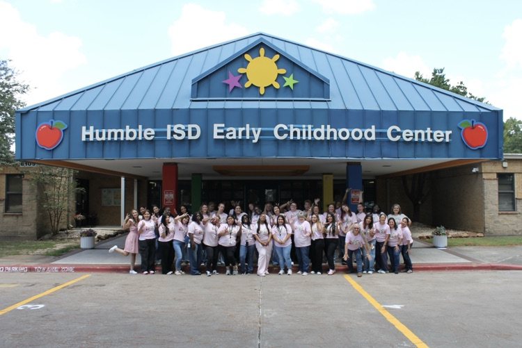 ECC staff takes a silly photo outside the building  