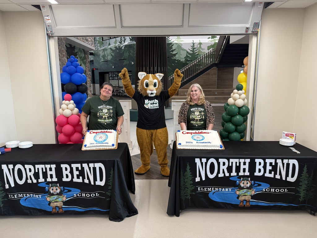 Admin staff displaying celebratory cake with NBE bobcat mascot