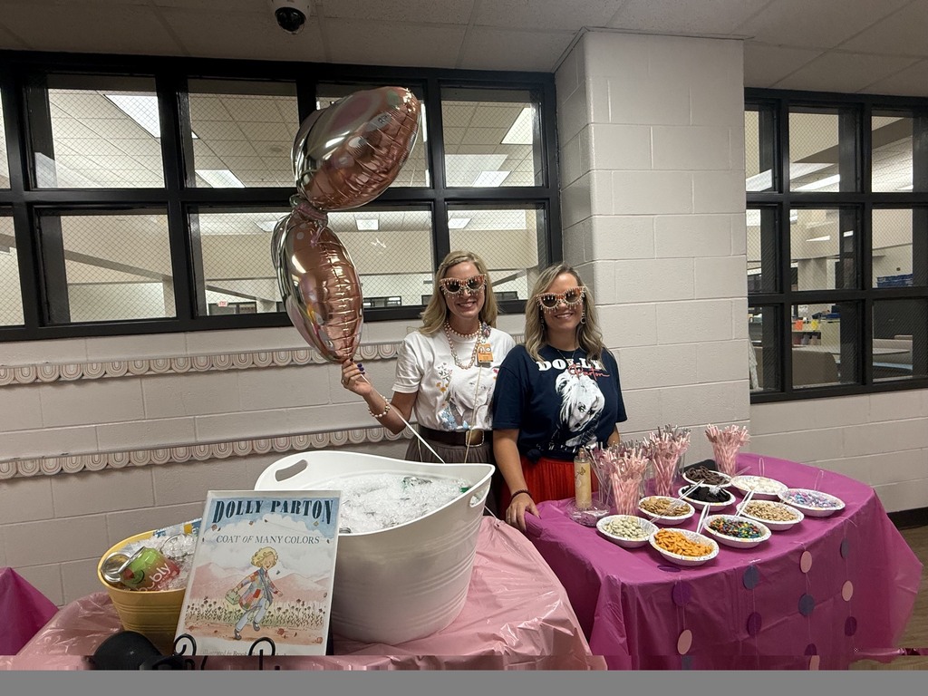 two Principals passing out goodies to staff