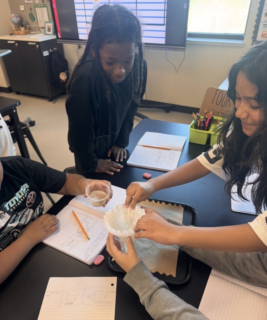 Students pouring their sand and saltwater solution into the filtration system.