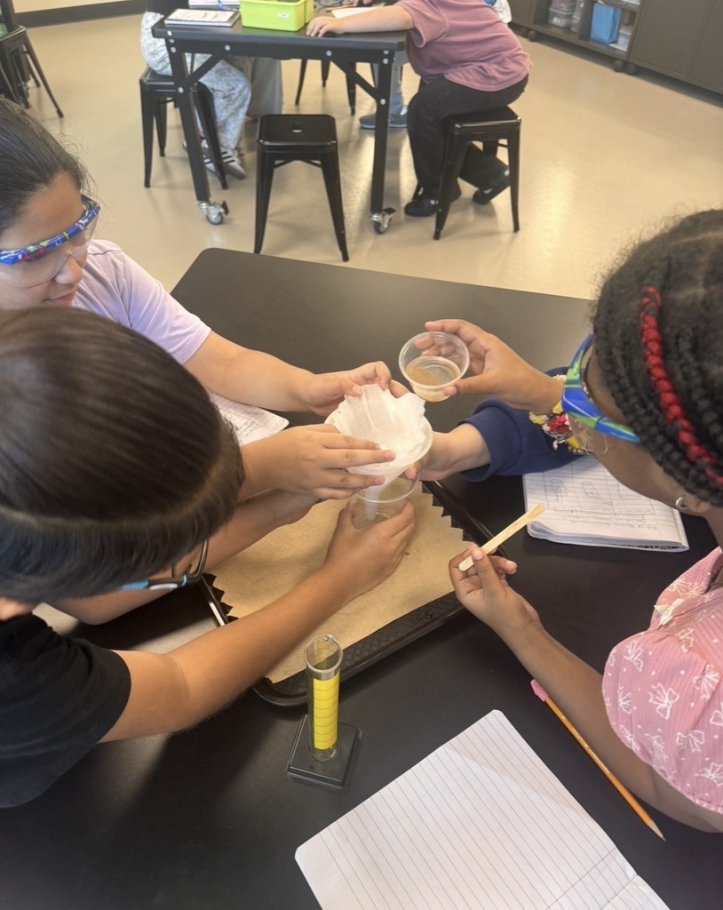 Students pouring their sand and saltwater solution into the filtration system.