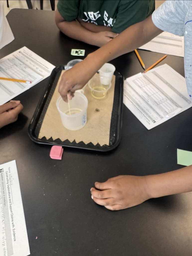 Students stirriing to see if the material is dissolvable in water.