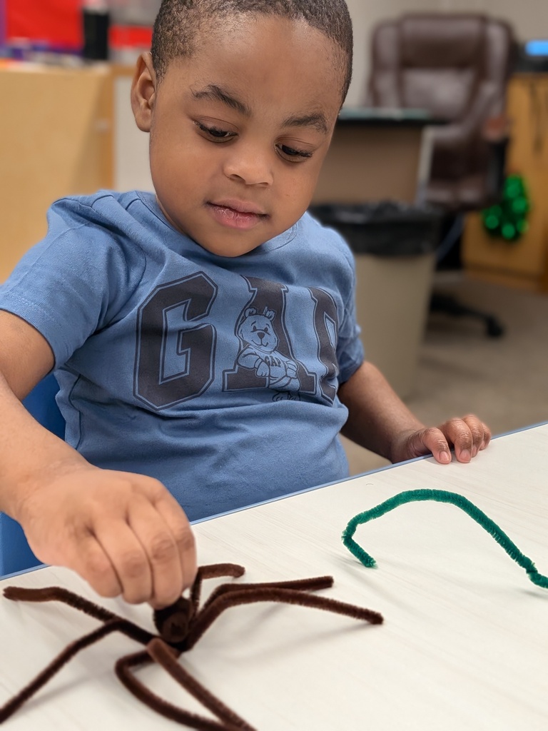 Student playing with a pipecleaner spider and snake