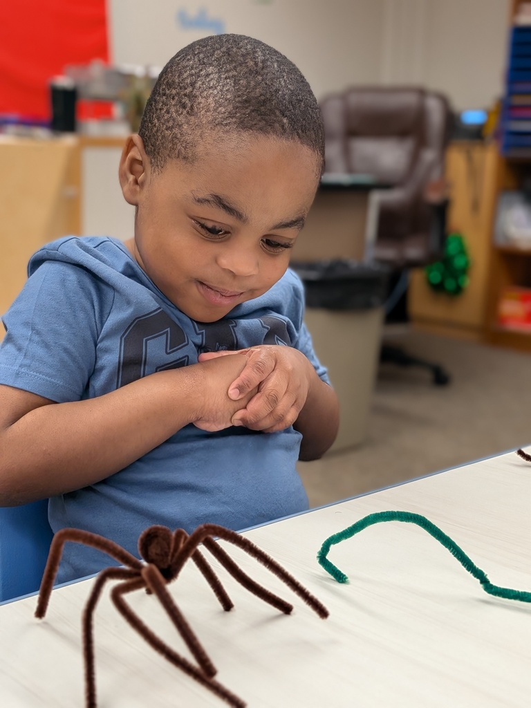 Student playing with a pipecleaner spider and snake