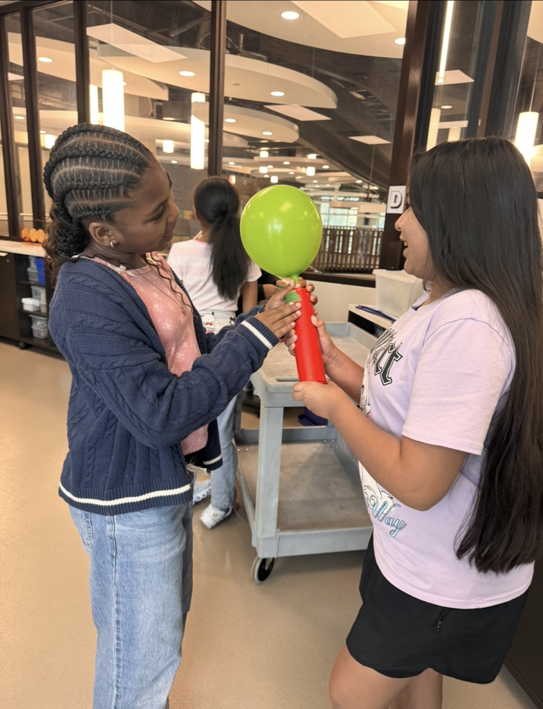 Students pumping air in their balloon rocket.