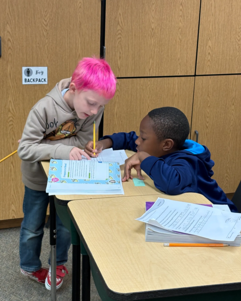 Students helping each other while writing