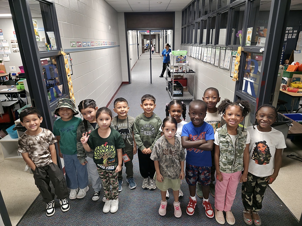 A hallway lined with glass doors and displays. A group of children standing in the hallway.