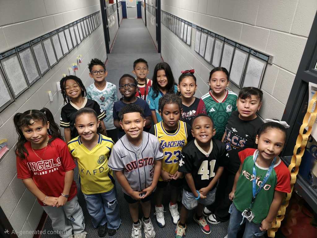 A group of children in various colors of shirts and pants stand in a school hallway.