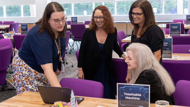 educators gathered around a computer
