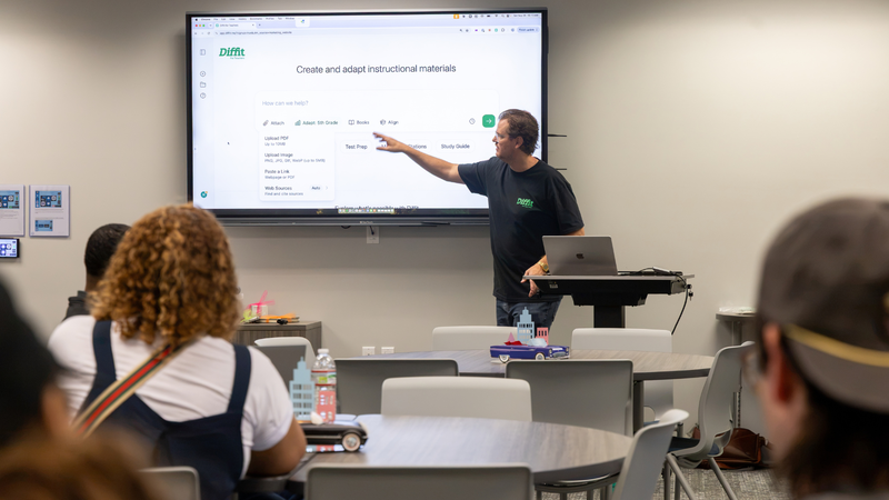 presenter pointing to a screen in front of teachers