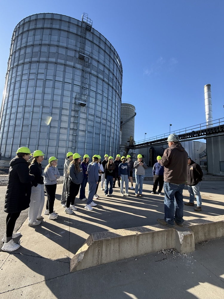 Students outside ethanol plants near the grain bins.