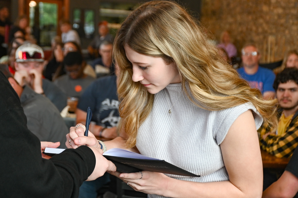 student signing pledge book